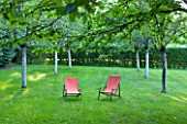 PRIEURE NOTRE-DAME DORSAN  FRANCE: THE CLOISTER OF THE THREE ORCHARDS - PINK DECK CHAIRS