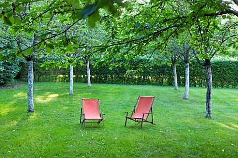 PRIEURE_NOTREDAME_DORSAN__FRANCE_THE_CLOISTER_OF_THE_THREE_ORCHARDS__PINK_DECK_CHAIRS