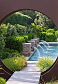 DESIGNER DOMINIQUE LAFOURCADE  PROVENCE  FRANCE: MODERN CONTEMPORARY GARDEN - METAL OCULUS CIRCLE AND SWIMMING POOL BEYOND WITH FOUR BRICK WATER SPOUTS