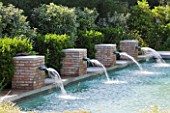 DESIGNER DOMINIQUE LAFOURCADE  PROVENCE  FRANCE: SWIMMING POOL WITH FOUR SQUARE BRICK FOUNTAINS THAT SPURT RE-CYCLED WATER BACK INTO SWIMMING POOL