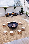 DESIGNER: CLARE MATTHEWS  DEVON - PAVING PROJECT - GRAVEL SEATING AREA WITH LARGE SQUARE WOODEN BLOCKS FOR SEATS AND FIRE CAULDRON
