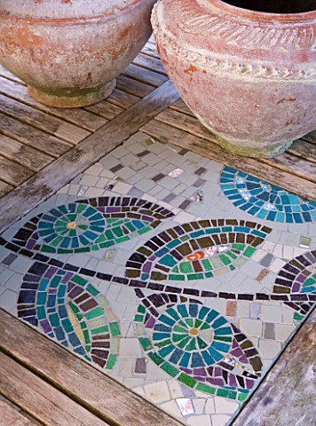 BARBARA_KENNINGTON_GARDEN__BRIGHTON_CONTAINERS_ON_THE_PATIO_TABLE_WITH_MOSAIC_INSETS