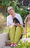 BARBARA KENNINGTON GARDEN  BRIGHTON: BARBARA ON THE STEPS WITH HER PET DACHSUND DOG BERTIE
