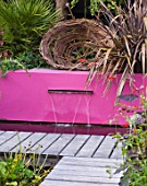 BARBARA KENNINGTON GARDEN  BRIGHTON: WOVEN WILLOW SCULPTURE ABOVE PINK RENDERED WALL AND LETTERBOX FOUNTAIN