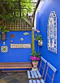 KARLA NEWELL GARDEN  BRIGHTON: SMALL TOWN GARDEN - COURTYARD WITH BLUE WALL PAINTED WITH POWDER PIGMENT  WOODEN BENCHES AND WOODEN PERGOLA