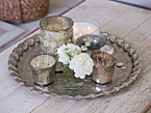 AMANDA KNOX HOUSE  GRANTHAM: THE WHITE SITTING ROOM - SILVER TEA LIGHT HOLDERS  CANDLES AND GLASS VASES ON A PATTERNED VINTAGE SILVER TRAY AS A COFFEE TABLE CENTRE PIECE