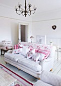 AMANDA KNOX HOUSE  GRANTHAM: THE WHITE SITTING ROOM - LINEN SOFAS  VINTAGE FABRIC CUSHIONS  WALLS PAINTED IN FARROW AND BALL ALL WHITE