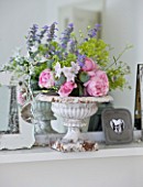 AMANDA KNOX HOUSE  GRANTHAM: THE LIVING ROOM - VINTAGE AND MODERN PICTURE FRAMES WITH WHITE CONTAINER FILLED WITH ROSES AND ALCHEMILLA MOLLIS ON MANTELPIECE ABOVE THE FIRE