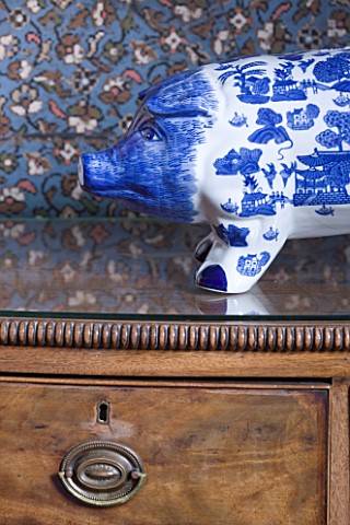 CHANTAL_COADY_HOUSE__LONDON_A_BLUE_AND_WHITE_PAINTED_PIGGY_BANK_ON_AN_ANTIQUE_CHEST_OF_DRAWERS_IN_TH
