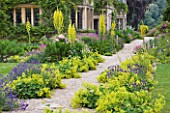 ASTHALL MANOR  OXFORDSHIRE: GRAVEL PATH AT FRONT OF HOUSE WITH ALCHEMILLA MOLLIS  VERBASCUM OLYMPICUM  LAVENDER  ROSES  GERANIUMS AND FOXGLOVES
