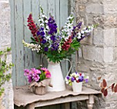 THE GARDEN AND PLANT COMPANY  HATHEROP CASTLE  CIRENCESTER  GLOUCESTERSHIRE: JUG WITH LUPINS  HESIAN POT OF DOUBLE COSMOS  PALE OF MIXED SWEET PEAS