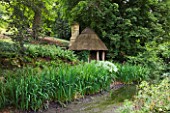 ASTHALL MANOR  OXFORDSHIRE: HERMITAGE BY THE POND BUILT OF AOK POSTS AND THATCH BY ISABEL BANNERMAN