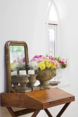 JACKY_HOBBS_HOUSE__LONDON_STONE_INDOOR_URN_FILLED_WITH_MIXED_DAHLIA_BOUQUET_WITH_STONE_CANDLE_PLINTH