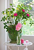 JACKY HOBBS HOUSE  LONDON: VINTAGE FRENCH BOTTLE VASE OF PINK DAHLIA GAY PRINCESS WITH PINK CANDLES AND LARGE VINTAGE GREEN FRENCH URN WITH ROSA GERTRUDE JEKYLL