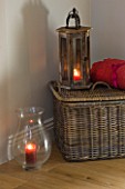 JACKY HOBBS HOUSE  LONDON: WICKER BASKET RED THROW AND WOODEN AND GLASS STROM LANTERNS WITH CANDLES