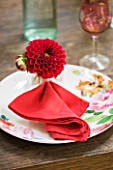 JACKY HOBBS HOUSE  LONDON: TABLE SETTING WITH FLORAL PLATE  RED NAPKIN AND RED DAHLIA FENSTERGUCKER