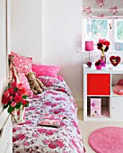 JACKY HOBBS HOUSE  LONDON: ROSE PRINTED FABRIC BAG FILLED WITH DEEP PINK ROSEBUDS HANGING FROM DOOR IN PINK BEDROOM WITH DISPLAY OF DEEP PINK AND RED DAHLIA BLOOMS