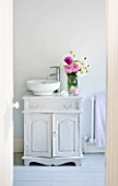 JACKY HOBBS HOUSE  LONDON: BATHROOM WITH VASE OF PINK AND WHITE DAHLIA BLOOMS.