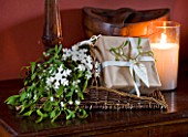 BASKET ON TABLE IN DINING ROOM WITH WRAPPED PRESENT AND MISTLETOE : STYLING BY JACKY HOBBS