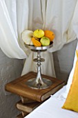 CHATEAU DU RIVAU  LOIRE VALLEY  FRANCE: THE BRIDAL ROOM BEDROOM WITH GOURDS AND PUMPKINS IN A METAL CONTAINER ON BOOK BEDSIDE TABLE IN THE ROYAL STABLES