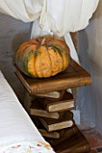 CHATEAU DU RIVAU  LOIRE VALLEY  FRANCE: THE BRIDAL ROOM BEDROOM WITH PUMPKIN ON BOOK BEDSIDE TABLE IN THE ROYAL STABLES