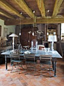 ROQUELIN  LOIRE VALLEY  FRANCE: DINING ROOM; WOODEN VINTAGE TABLE SET WITH FOLDING WOODEN AND METAL GARDEN CHAIRS  BEAMED CEILING AND TILED FLOOR