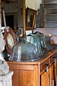 ROQUELIN  LOIRE VALLEY  FRANCE: DINING ROOM; WOODEN DRESSER WITH DISPLAY OF VINTAGE GREEN GLASS GARDEN CLOCHES