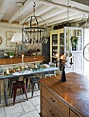 ROQUELIN  LOIRE VALLEY  FRANCE: KITCHEN; VINTAGE SHOP COUNTER AS MAIN ISLAND UNIT  HANGING KNIFE AND FORK RACK  ZINC TOP TABLE AND BUTCHERS BLOCK DRESSER