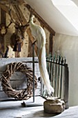 ROQUELIN  LOIRE VALLEY  FRANCE: UPPER HALL; DECORATIVE WHITE PEACOCK ON STAND  WITH DEER HEAD TROPHIES ON WALL