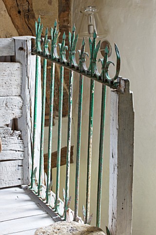 ROQUELIN__LOIRE_VALLEY__FRANCE_UPPER_HALL_AN_OLD_DECORATIVE_IRON_GATE_SAFEGUARDS_THE_STAIR_HEAD