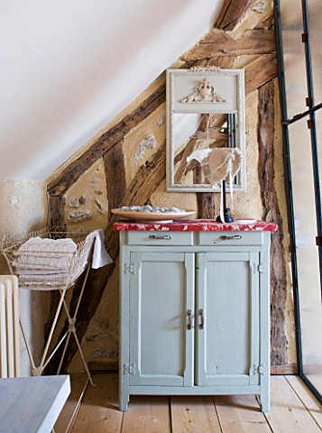 ROQUELIN__LOIRE_VALLEY__FRANCE_BATHROOM_A_SMALL_BATHROOM_FITS_UNDER_THE_ROOF_EAVES_WITH_PAINTED_WOOD