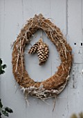 ROQUELIN  LOIRE VALLEY  FRANCE: OUTHOUSE DOOR; A SIMPLE TWIG AND CONE CHRISTMAS WREATH
