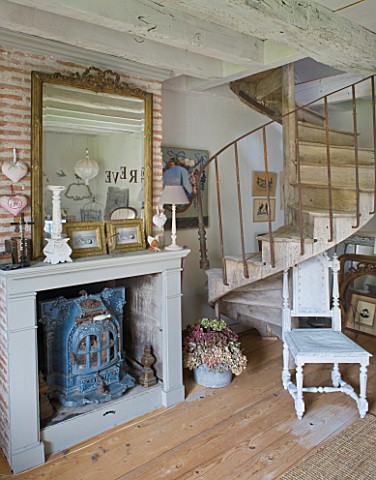 ROQUELIN__LOIRE_VALLEY__FRANCE_MASTER_BEDROOM_ENAMEL_STOVE_IN_FIREPLACE_WITH_GILT_MIRROR_AT_FOOT_OF_