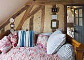 ROQUELIN  LOIRE VALLEY  FRANCE: SEWING ROOM; WOODEN WALL BEAMS  VINTAGE FRENCH WOODEN DAY BED WITH SELECTION OF VINTAGE FABRIC QUILTS AND CUSHIONS