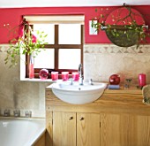 RICKYARD BARN HOUSE  OXFORDSHIRE: DESIGNERS JANE AND CLIVE NICHOLS. BATHROOM WITH TILES AND SINK  RED/PINKWALLS  MISTLETOE ON MIRROR - CHRISTMAS