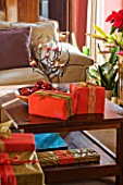 RICKYARD BARN HOUSE  OXFORDSHIRE: DESIGNERS JANE AND CLIVE NICHOLS. LIVING ROOM AT CHRISTMAS WITH WRAPPED PRESENTS ON COFFEE TABLE