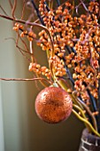 RICKYARD BARN HOUSE  OXFORDSHIRE: DESIGNERS JANE AND CLIVE NICHOLS: CHRISTMAS DECORATION - CONTAINER WITH BERRIES  TWIGS AND BAUBLES