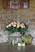RICKYARD BARN HOUSE  OXFORDSHIRE: DESIGNERS JANE AND CLIVE NICHOLS. LIVING ROOM - WRAPPED PRESENTS AND BASKET FILLED WITH ROSES