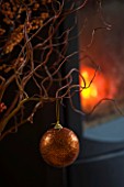 RICKYARD BARN HOUSE  OXFORDSHIRE: DESIGNERS JANE AND CLIVE NICHOLS. TWIGS AND BAUBLE IN FRONT OF FIRE AT CHRISTMAS