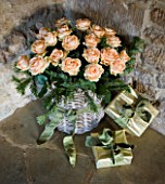 RICKYARD BARN HOUSE  OXFORDSHIRE: DESIGNERS JANE AND CLIVE NICHOLS. WRAPPED PRESENTS AND BASKET WITH ROSES IN THE LIVING ROOM