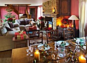 RICKYARD BARN  OXFORDSHIRE: CHRISTMAS - LIVING ROOM - DINING TABLE DECORATED WITH FIGS AND FIG LEAVES  SOFAS AND CHRISTMAS TREE