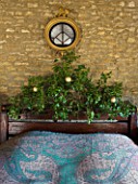 RICKYARD BARN  OXFORDSHIRE: CHRISTMAS - BEDROOM - GOLD LEAF EAGLE MIRROR ABOVE BED  BLUE BED SPREAD AND IVY DECORATED HEADBOARD