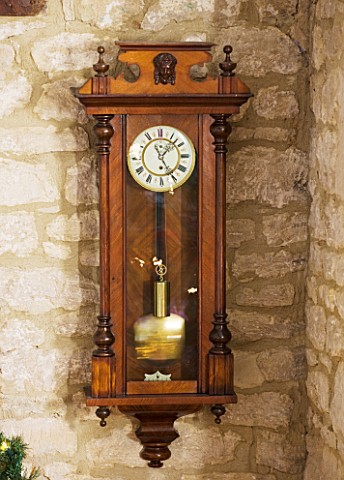 FULBROOK_HOUSE_ANTIQUE_WOODEN_WALL_CLOCK_HANGS_IN_COTSWOLD_STONE_HALLWAY