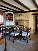 FULBROOK HOUSE: DINING ROOM SET FOR ENTERTAINING WITH TERRACOTTA PAINTED WALL  BEAMED CEILING AND STONE FLOOR