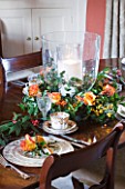 FULBROOK HOUSE: DINING ROOM; CHRISTMAS TABLE WREATH AND CANDLE CENTREPIECE WITH ORANGE/YELLOW ROSES AND SEASONAL FOLIAGE
