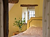 FULBROOK HOUSE: YELLOW DOUBLE BEDROOM WITH EAVED CEILING AND BEAMS.