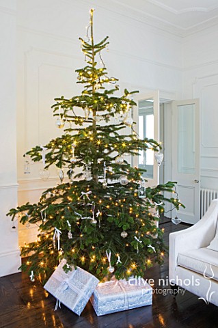 WHITE_HOUSE_SITTING_ROOM_WHITE_DCOR_AND_FURNISHINGS_WITH_DARK_WOOD_FLOORS__CHRISTMAS_TREE_AND_PRESEN
