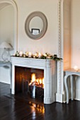 WHITE HOUSE: RECEPTION HALL - FIREPLACE WITH CIRCULAR MIRROR AND MANTLE DECORATED WITH SEASONAL FOLIAGE  FLOWERS AND CANDLES