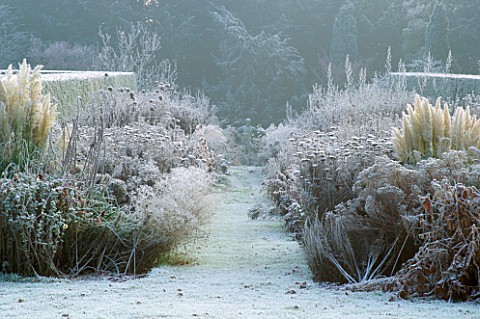 VIEW_FROM_HOUSE_ALONG_THE_FROST_COVERED_DOUBLE_HERBACEOUS_BORDERS_TO_ROMAN_STATUE_OLD_RECTORY__BURGH