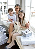WHITE HOUSE: MOTHER WITH HER TWO CHILDREN AND PET DOG IN DINING ROOM SITTING ON WINDOW SEAT WITH CHRISTMAS PRESENTS